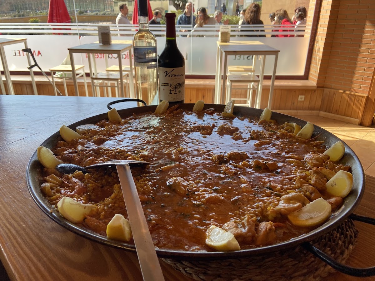 Paella mixta con marisco y carne, adornada con limón