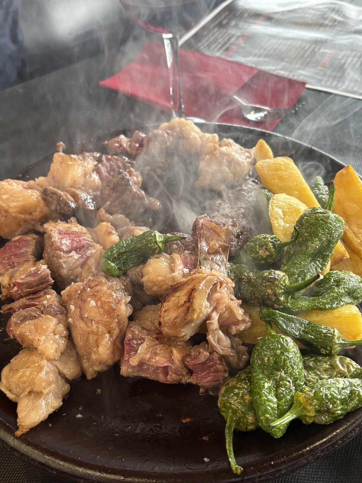 Plato de carne asada a la parrilla con pimientos y patatas fritas